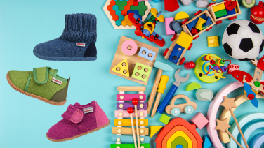 Three colourful children's shoes with Velcro fastenings next to various wooden toys on a turquoise background