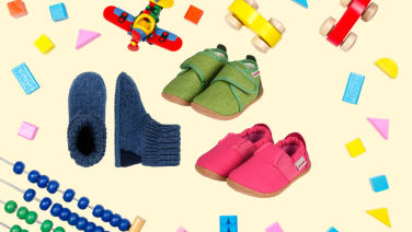 Children's shoes in various colours and styles surrounded by colourful toys on a beige background